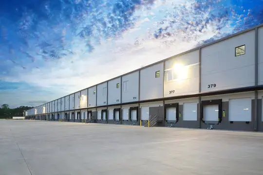 Exterior view of a large modern warehouse distribution facility with loading docks
